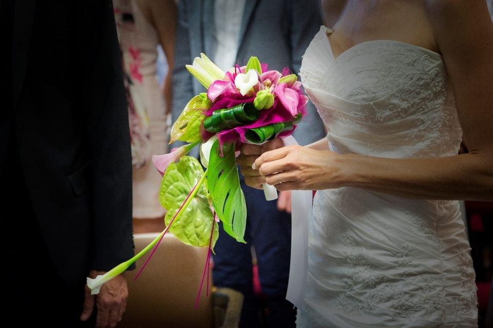 Mariée dans une belle robe tenant un bouquet de fleurs