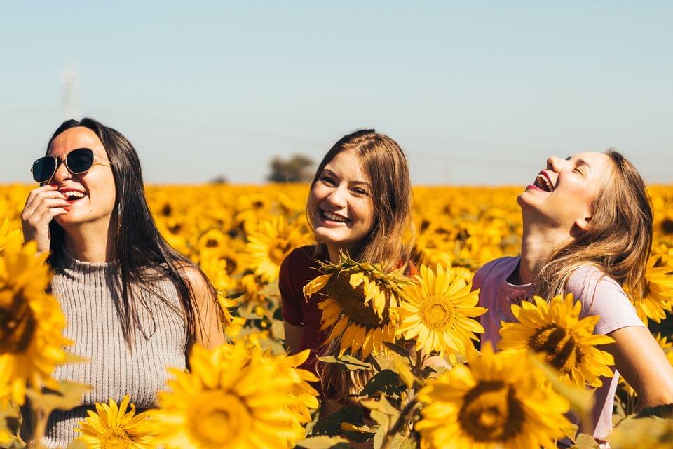 Trois jeunes femmes dans un champ de fleurs